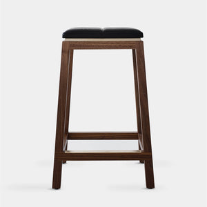 front on view of a solid walnut designer kitchen stool sitting on a white floor in Melbourne