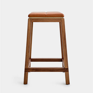 Front on view of a solid wood modern kitchen stool with supple tan leather seat