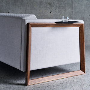 solid walnut wood arms float a soft wool sofa off a polished concrete floor